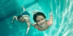 Father and daughter swimming, underwater view- Clearwater Pools